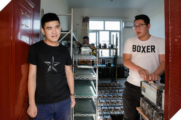 
Những thợ mỏ làm việc tại mỏ bitcoin đang chuẩn bị lắp máy vào kệ
