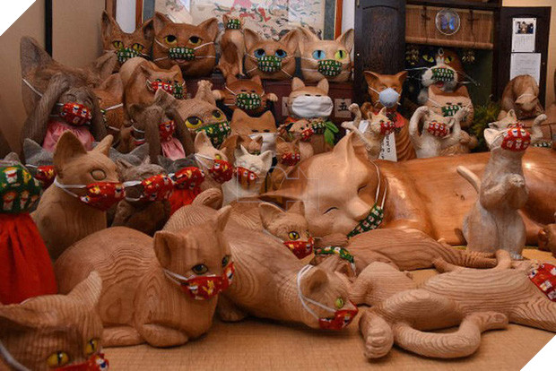 Ngôi đền đặc biệt ở Nhật Bản được mệnh danh là Đền Mèo, trụ trì tự tay làm khẩu trang cho hàng trăm chú mèo gỗ từ tã lót trẻ em - Ảnh 1.