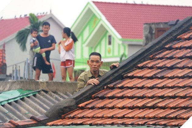  
Người cao tuổi, trẻ em phải trèo lên nóc nhà chờ cứu. (Ảnh: Thanh Niên)
