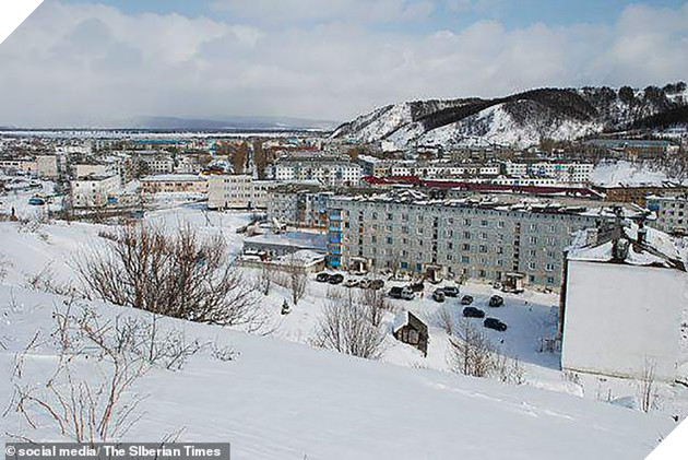 Vika Z was found with frostbite hugging the 'fluffy' abandoned pet following a frantic search by police, officials and volunteers. Pictured: File photo of Uglegorsk covered in snow